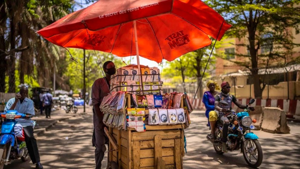 ARCHIVE - A street vendor sells cell phone accessories in Bamako, the capital of Mali. Photo: Michael Kappeler/dpa/Symbolic image