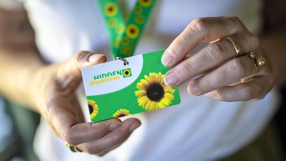 Après les CFF dans certaines gares, l'aéroport de Zurich introduit à son tour la possibilité pour les personnes souffrant d'un handicap non visible de porter un cordon vert à motifs de tournesols autour du cou.