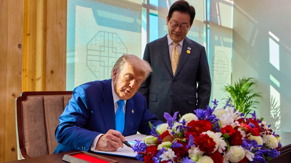 US-Präsident Donald Trump (l.), zusammen mit dem südkoreanischen Präsidenten Lee Jae Myung abgebildet, trägt sich am Mittwoch vor dem APEC-Gipfel in Südkorea in das Gästebuch des Nationalmuseums von Gyeongju ein.