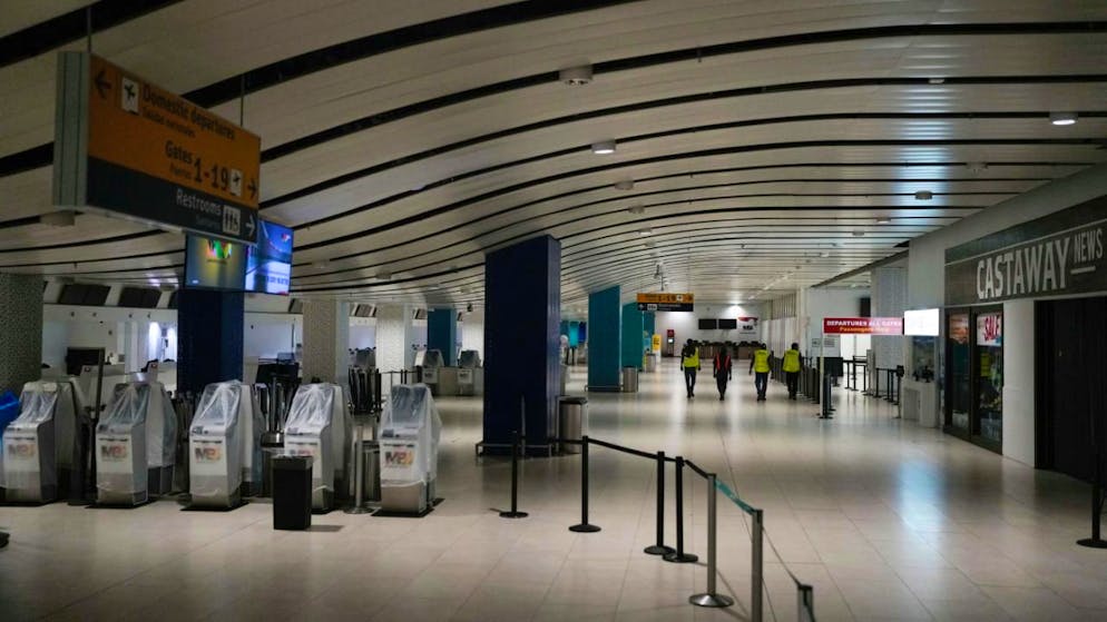 Arbeiter gehen durch den Sangster International Airport in Montego Bay. Foto: Matias Delacroix/AP/dpa