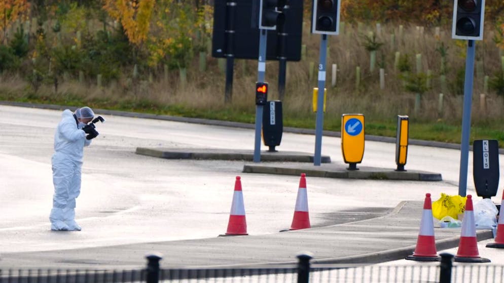 Ein Gerichtsmediziner macht Fotos von der Straße, die zum Bahnhof führt. Foto: Kirsty Wigglesworth/AP/dpa