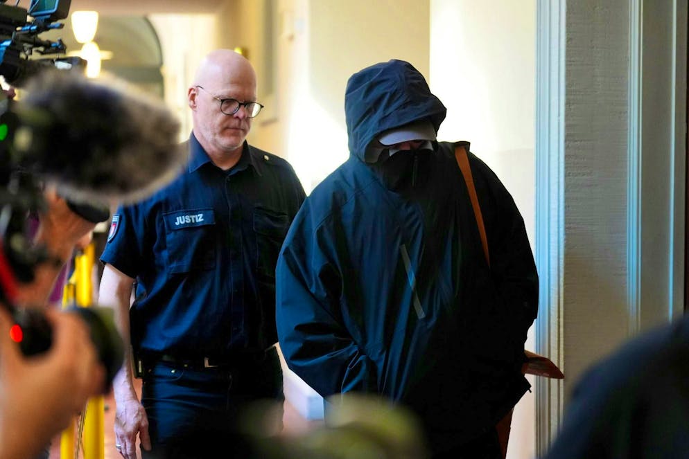 Celebrity trial over abduction of the Block children - Gallery. A defendant is escorted to the courtroom by a police officer. 