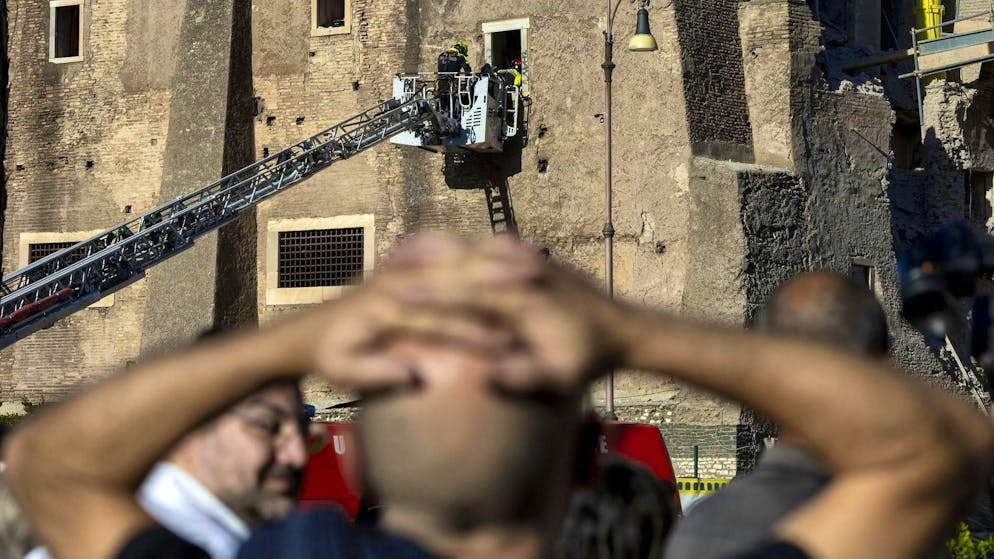Trapped construction worker dies after tower collapse in Rome - Gallery. Onlookers follow the firefighters' workers.