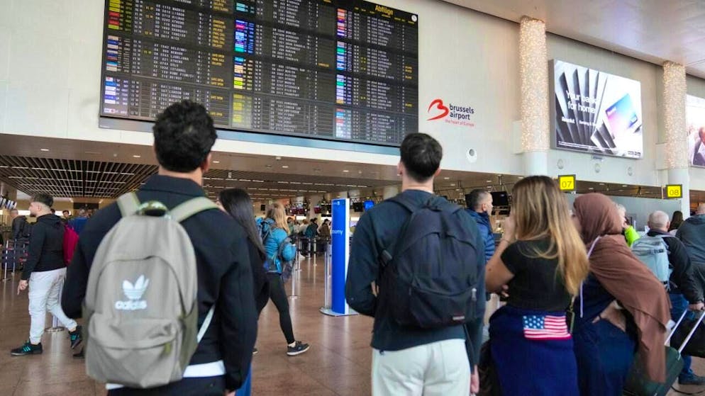 Passengers look at a departure board after several flights were canceled. Photo: Virginia Mayo/AP/dpa