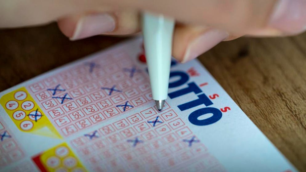 Una persona riempie una scheda del Lotto (immagine d'archivio)