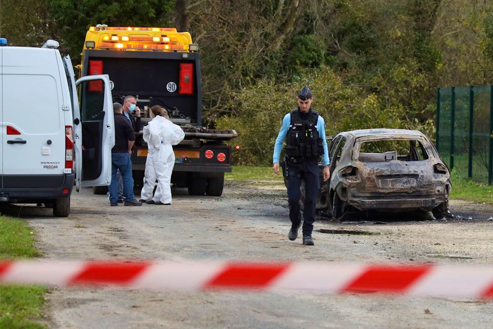 Des enquêteurs se tiennent près de la voiture incendiée après qu'un automobiliste ait délibérément percuté des piétons et des cyclistes dans deux villes voisines de l'île d'Oléron, au large de la côte atlantique, blessant plusieurs personnes avant d'être arrêté par les gendarmes, mercredi 5 novembre 2025 à Saint-Pierre-d'Oléron. (AP Photo/Yohan Bonnet)