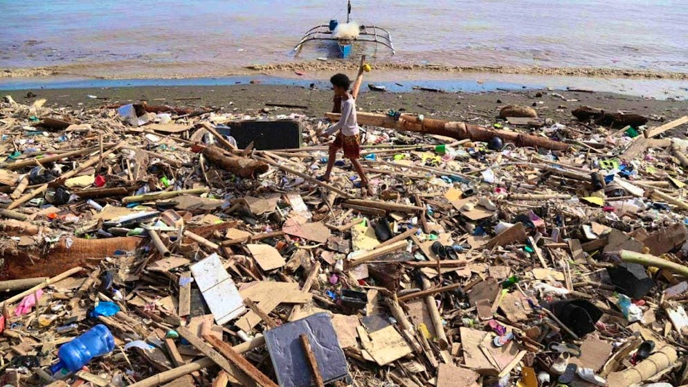 dpatopictures - Residents walk along the rubble after Typhoon Kalmaegi a caused devastation. Photo: Jacqueline Hernandez/AP/dpa