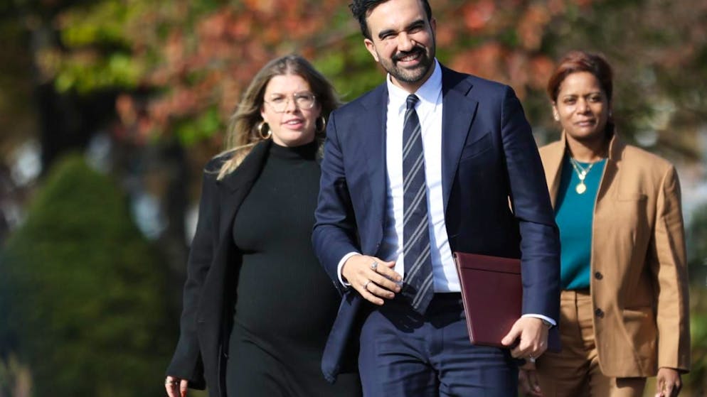 Der gewählte Bürgermeister von New York City, Zohran Mamdani geht mit Mitgliedern seines Übergangsteams, darunter Elana Leopold (l) und Melanie Hartzog, zu einer Pressekonferenz im New Yorker Stadtteil Queens. Foto: Heather Khalifa/FR172147 AP/AP/dpa