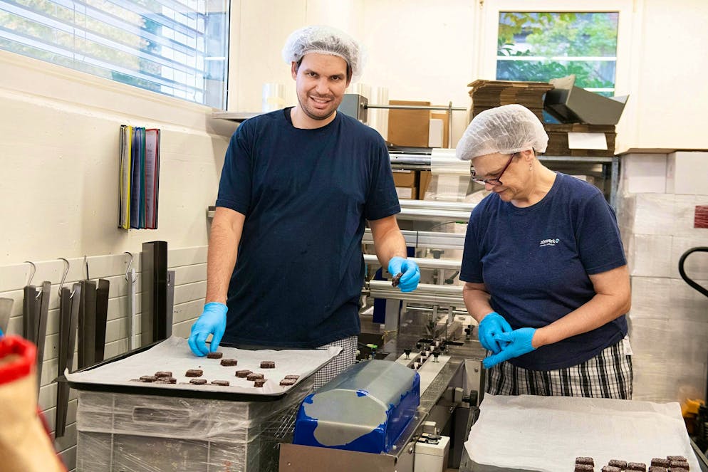 UBS Helpetica cuisson. Vincent et Jacqueline emballent les bruns de Bâle individuellement à l’aide d’une machine.
