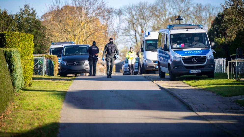 Polizeiautos stehen vor einem Wohnhaus in Reimershagen. Nach zahlreichen Hinweisen bei «Aktenzeichen XY» durchsucht die Polizei erneut mehrere Objekte in Reimershagen und im Nachbarort Rum Kogel. Foto: Philip Dulian/dpa - ACHTUNG: Kennezeich(en) wurde(n) aus rechtlichen Gründen gepixelt