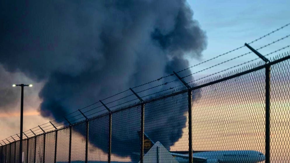A UPS Boeing 737 is parked as a plume of smoke from the crash of a UPS cargo plane is seen nearby at Louisville Muhammad Ali International Airport in the background. Photo: Jon Cherry/AP/dpa