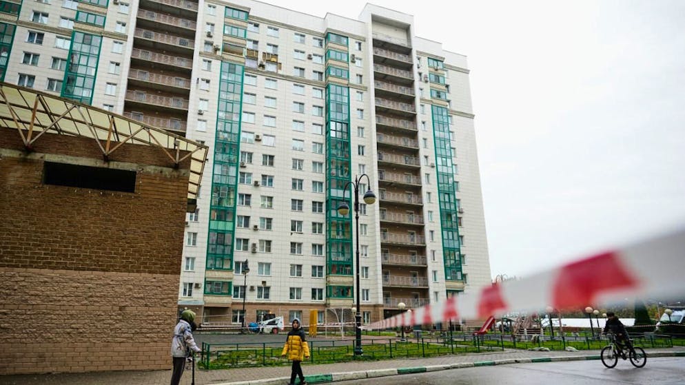Ein städtischer Angestellter, oben im Hintergrund, arbeitet an der Seite eines beschädigten mehrstöckigen Wohnhauses, das mutmaßlich von einer ukrainischen Drohne getroffen wurde in der Moskauer Vorstadt Krasnogorsk. Foto: Pavel Bednyakov/AP/dpa