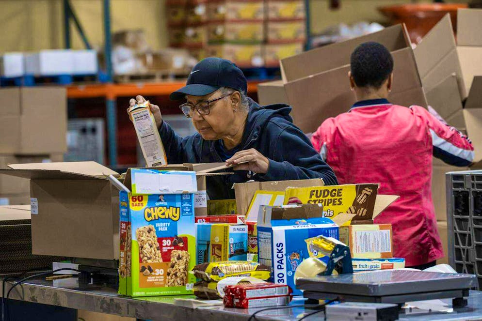 A volunteer from the Harvesters organization packs food packages at the distribution center in Kansas City, Missouri, on October 28, 2025.