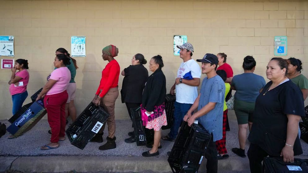 ARCHIV - Menschen warten in einer Schlange vor einer Verteilerstelle der Central Texas Food Bank. Foto: Jay Janner/Austin American-Statesman/dpa - ACHTUNG: Nur zur redaktionellen Verwendung und nur mit vollständiger Nennung des vorstehenden Credits