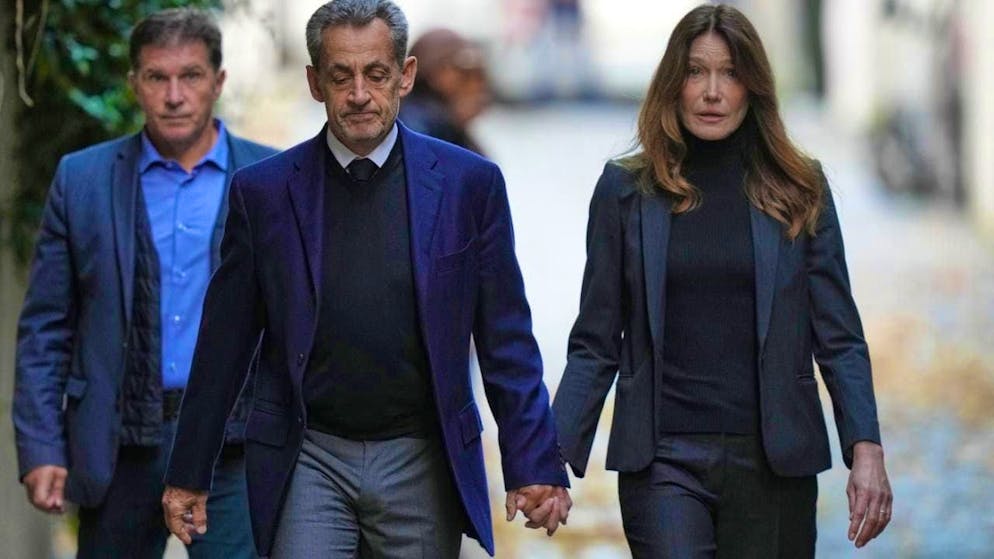 ARCHIVE - Former French President Nicolas Sarkozy and his wife Carla Bruni-Sarkozy leave their home in Paris while Sarkozy goes to prison to serve his sentence for a criminal conspiracy to finance his 2007 election campaign with money from Libya. Photo: Thibault Camus/AP/dpa