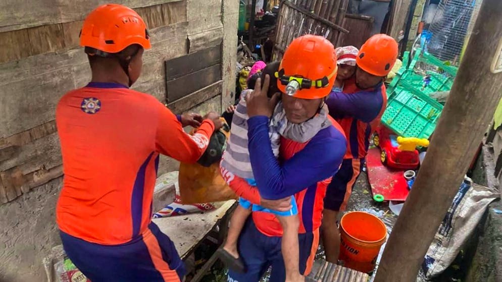 HANDOUT - Auf diesem von der philippinischen Küstenwache zur Verfügung gestellten Foto evakuieren Rettungskräfte Bewohner im Ort Virac. Foto: Uncredited/Philippine Coast Guard/AP/dpa - ACHTUNG: Nur zur redaktionellen Verwendung und nur mit vollständiger Nennung des vorstehenden Credits