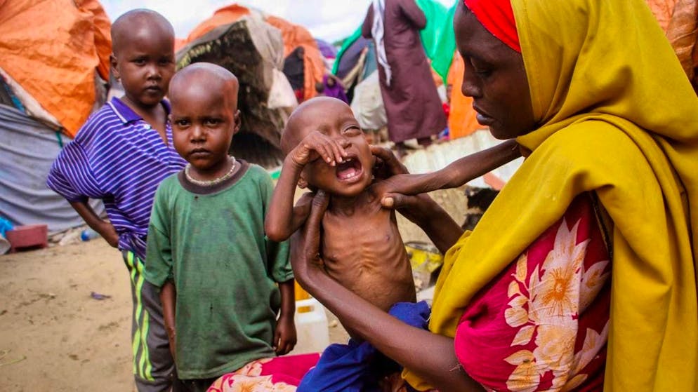ARCHIVE - Maryan Madey (r), who fled the drought-stricken Lower Shabelle region, holds her malnourished daughter Deka Ali in a camp for displaced people on the outskirts of Mogadishu. Photo: Farah Abdi Warsameh/AP/dpa