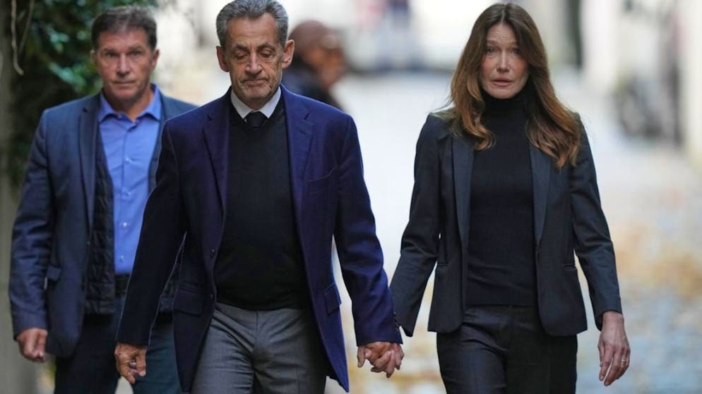ARCHIV - Der ehemalige französische Präsident Nicolas Sarkozy und seine Frau Carla Bruni-Sarkozy verlassen ihr Haus in Paris, während Sarkozy ins Gefängnis geht, um seine Strafe für eine kriminelle Verschwörung zur Finanzierung seines Wahlkampfes 2007 mit Geldern aus Libyen abzusitzen. Foto: Thibault Camus/AP/dpa