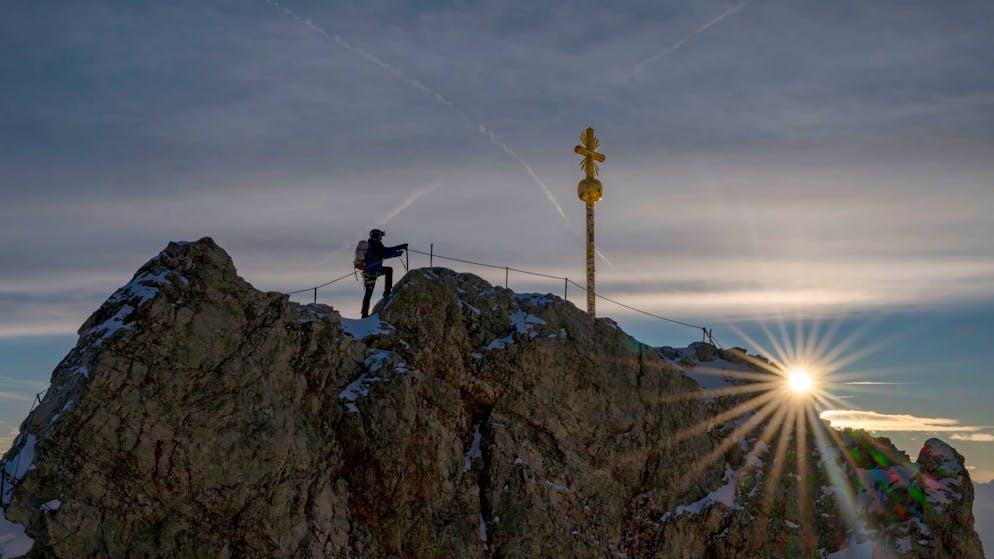 Elaborate restoration. Sneaker tourists cover golden summit cross with stickers