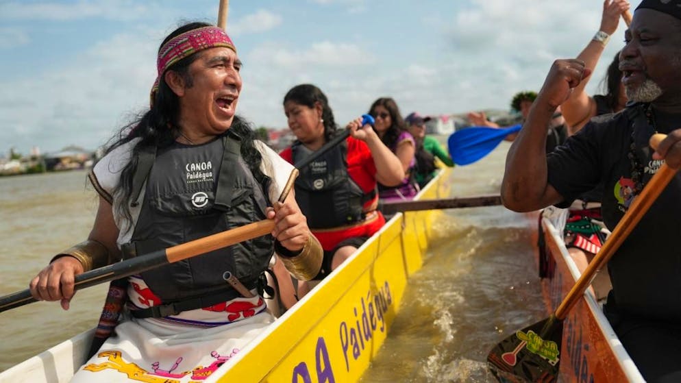Indigene nehmen an der Veranstaltung People's Summit in der Guajara-Bucht während der Weltklimakonferenz COP30 teil. Rund 200 Staaten verhandeln in Brasilien zwei Wochen lang darüber, wie die Erderwärmung eingedämmt werden kann. Foto: Joshua A. Bickel/AP/dpa