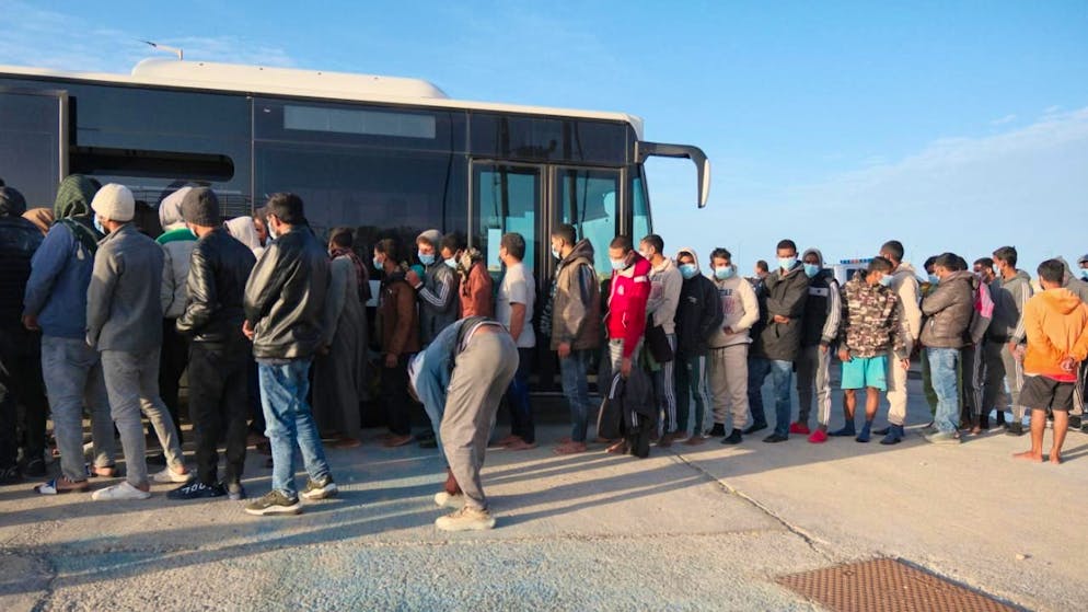 ARCHIV - Migranten gehen zu einem Bus im Hafen von Paliochora auf der Insel Kreta (Archivbild). Foto: Giannis Angelakis/AP/dpa