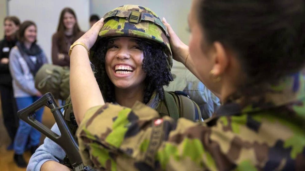 A young woman tries on 39 kilograms of equipment at an army orientation day. The Federal Council wants the orientation day to be compulsory for all young women. (archive picture)