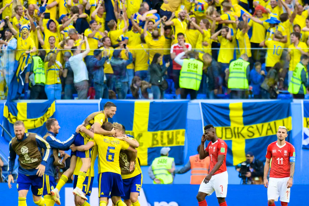 Two worlds: The Swedes celebrate reaching the quarter-finals of the 2018 World Cup, while the Swiss are disappointed.