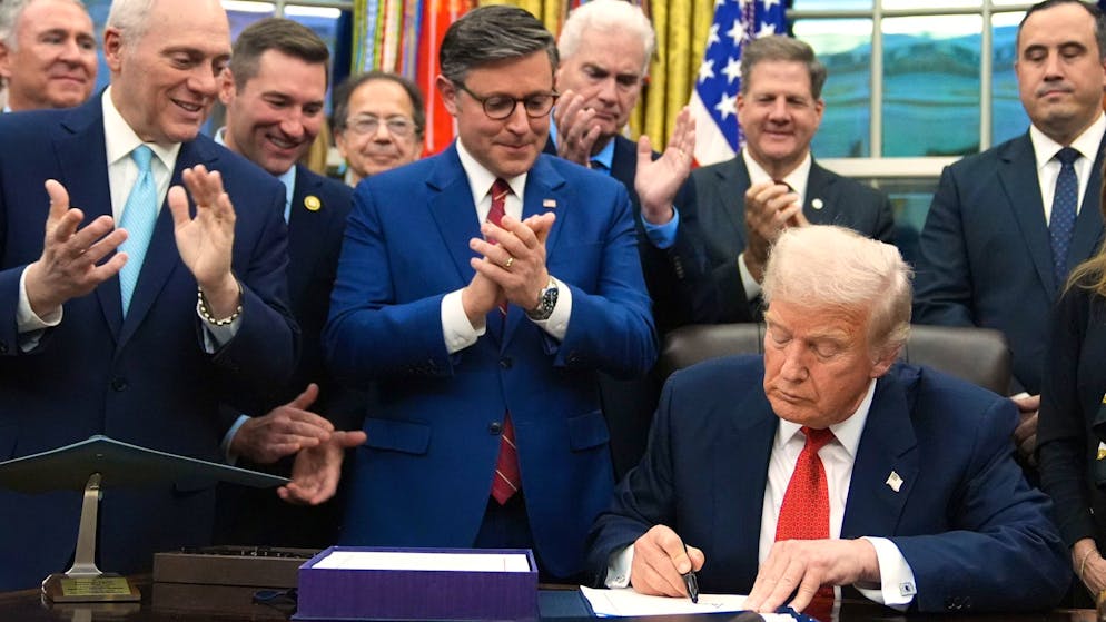 US-Präsident Donald Trump unterschreibt am Mittwochabend im Oval Office den Übergangshaushalt – hinter ihm applaudieren Mike Johnson, der Vorsitzende des US-Repräsentantenhauses, und andere republikanische Abgeordnete.