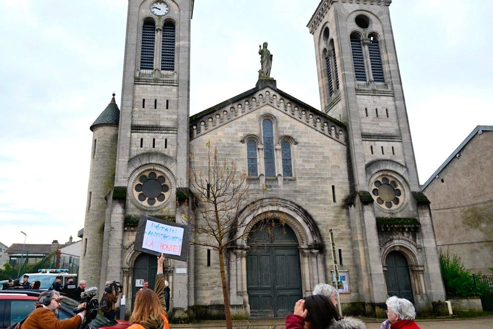 Une femme brandit une pancarte sur laquelle on peut lire « Pétain = antisémitisme, honte ! » lors d'une manifestation devant l'église Saint-Jean-Baptiste, où se déroule une cérémonie religieuse « en hommage au maréchal Pétain et à ses soldats ».