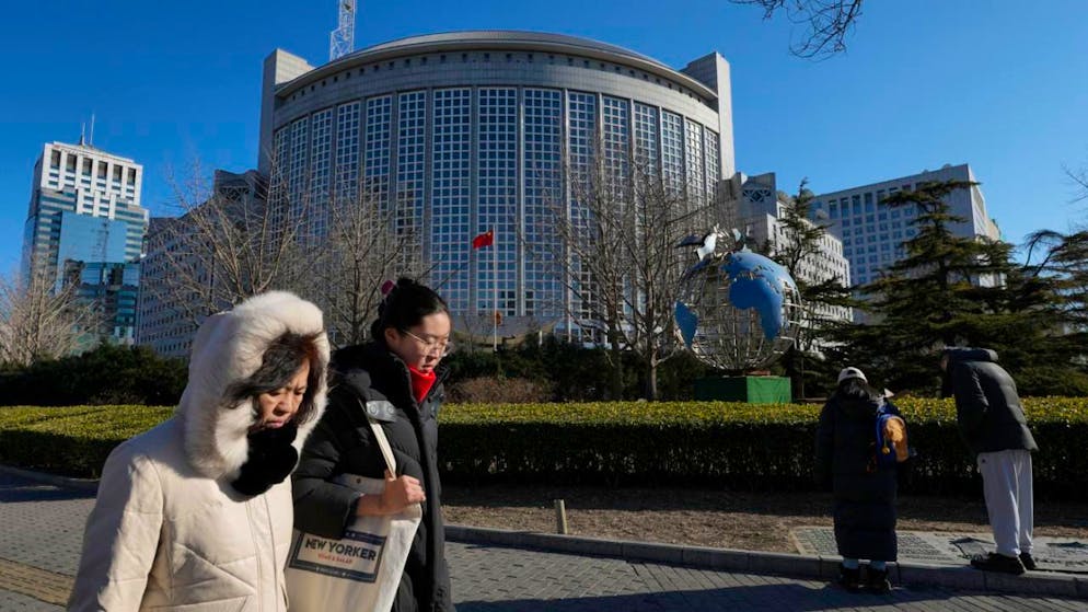 ARCHIV - Menschen gehen am chinesischen Außenministerium vorbei. Foto: Andy Wong/AP/dpa