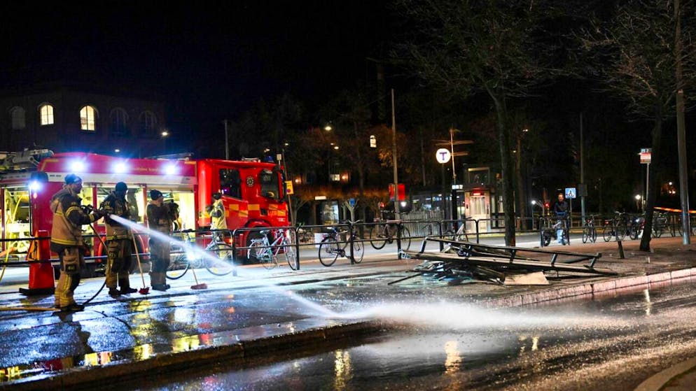 Feuerwehrleute versprühen Wasser an der Unfallstelle, nachdem ein Bus in eine Bushaltestelle gekracht ist. Foto: Henrik Montgomery/TT News Agency/AP/dpa - ACHTUNG: Nur zur redaktionellen Verwendung und nur mit vollständiger Nennung des vorstehenden Credits