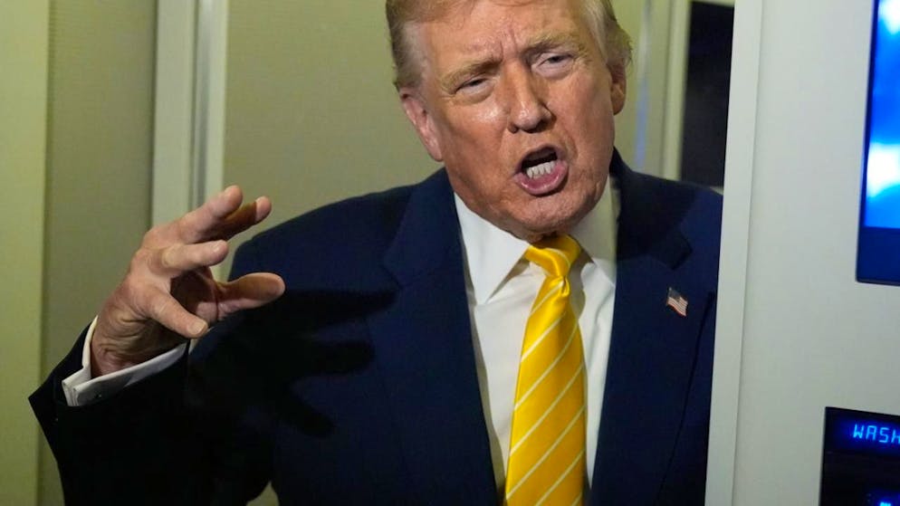 US-Präsident Donald Trump spricht zu Reportern in der Air Force One auf dem Weg zu seinem Anwesen Mar-a-Lago. Foto: Manuel Balce Ceneta/AP/dpa