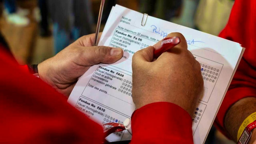 Fribourg native wins the Fondue World Championships in Tartegnin VD - Gallery. A jury member evaluates one of the competition fondues.