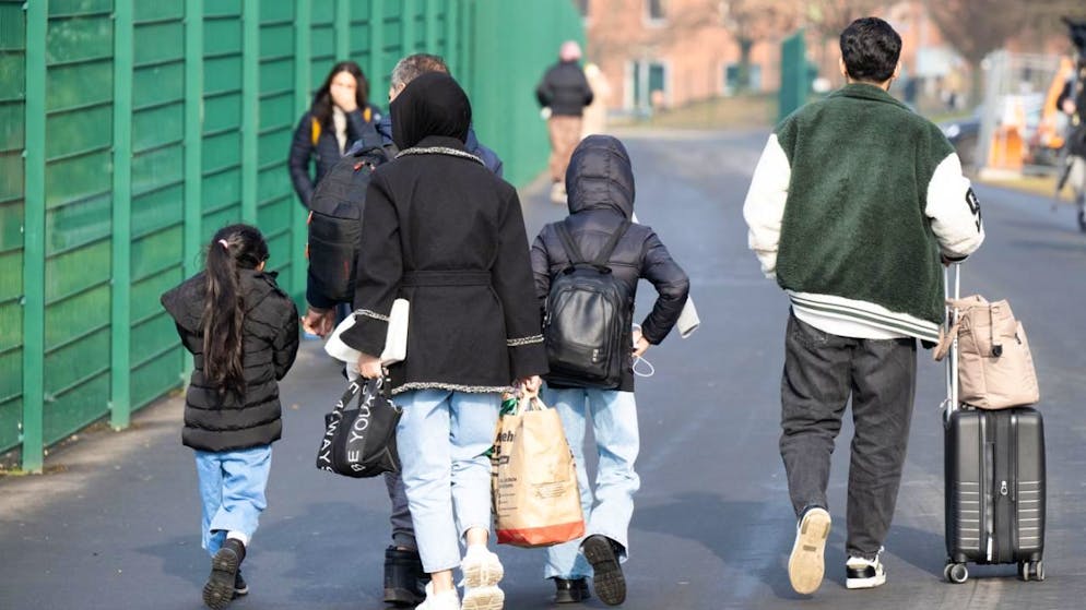 ARCHIV - Flüchtlinge gehen zu einer Unterkunft. Foto: Boris Roessler/dpa