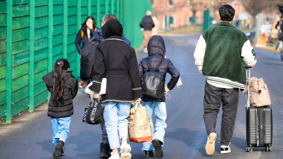 ARCHIVE - Refugees walk to a shelter. Photo: Boris Roessler/dpa