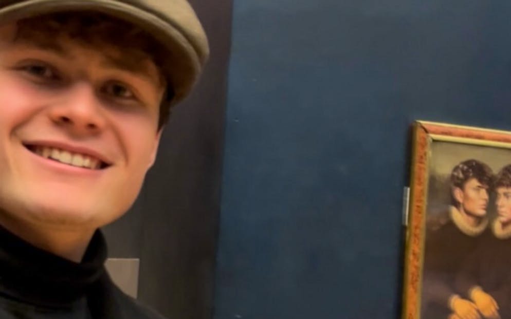 Zwei junge Männer spielen dem weltberühmten Louvre einen Streich und hängen ein eigenes Bild an doie Wand.