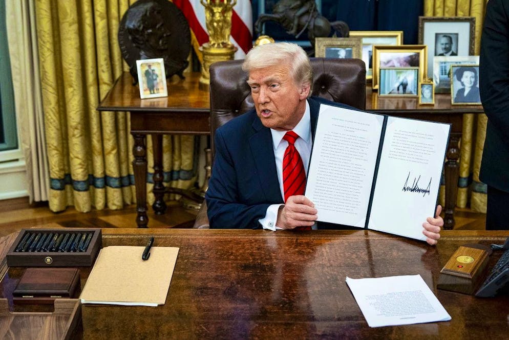 Trump shows one of his "executive orders" (theme picture)
