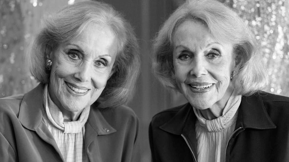 Die Kessler-Zwillinge, Alice (l.) und Ellen Kessler, posieren bei einem exklusiven Fototermin nach der Auftaktveranstaltung zu einer Online-Versteigerung ihrer Bühnenoutfits im Gärtnerplatztheater. Foto: Lennart Preiss/dpa