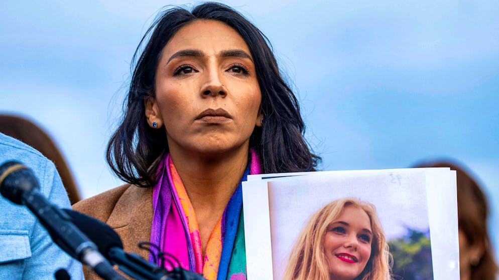 Amanda Roberts holds up a picture of her sister-in-law Virginia Giuffre in front of the US Capitol. Jeffrey Epstein's best-known victim committed suicide in April. (November 18, 2025)