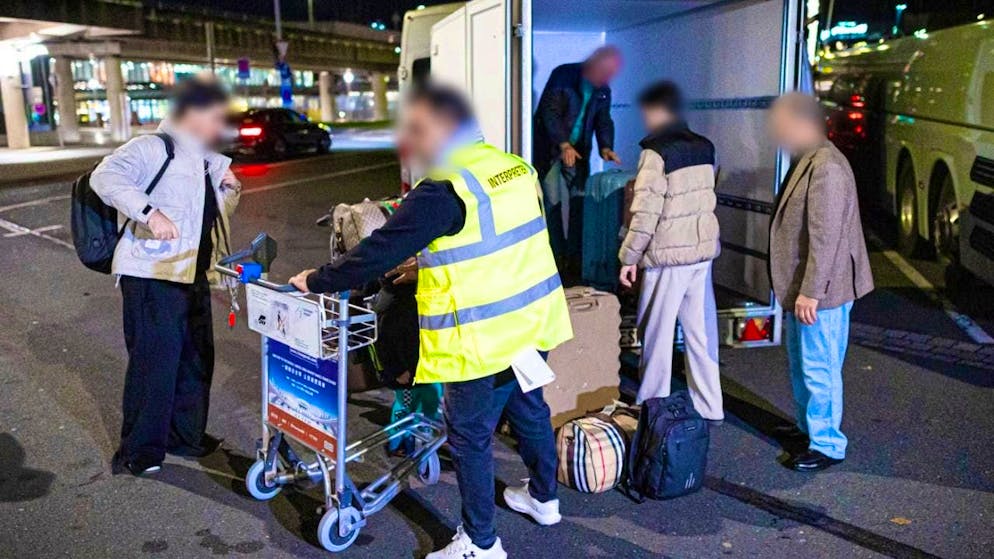 ARCHIVE - People from Afghanistan who have landed at Hanover-Langenhagen Airport stand in front of the airport and load their luggage. Only a few of the Afghans concerned have accepted a financial offer from the German government to waive their admission to Germany. Photo: Moritz Frankenberg/dpa - ATTENTION: Person(s) has/have been pixelated for legal reasons