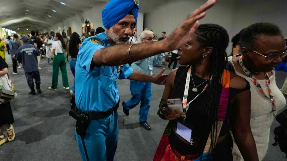 dpatopbilder - A security guard instructs people to leave the venue of the COP30 World Climate Conference. Photo: Fernando Llano/AP/dpa