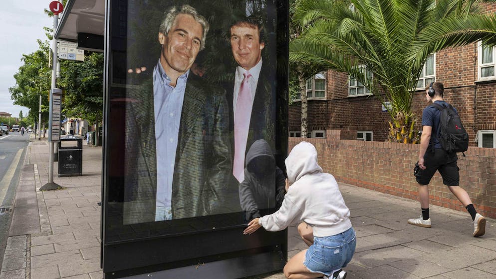 Aktivisten installieren an einer Bushaltestelle nahe der US-Botschaft in London ein Poster, das US-Präsident Donald Trump mit dem Sexualstraftäter Jeffrey Epstein zeigt. (17. Juli 2025)