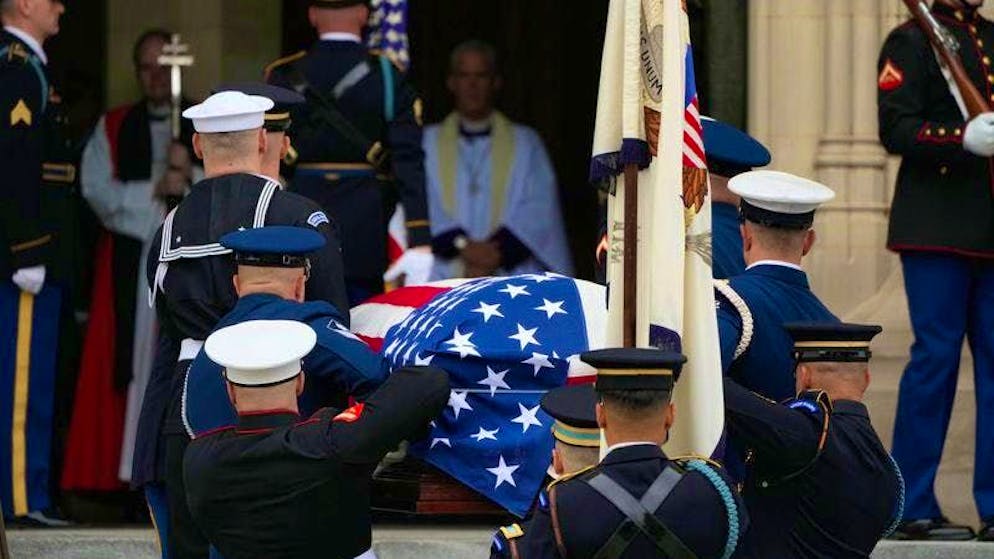 A team of pallbearers carries the coffin of former US Vice President Dick Cheney, covered with a US flag, into the Washington National Cathedral.