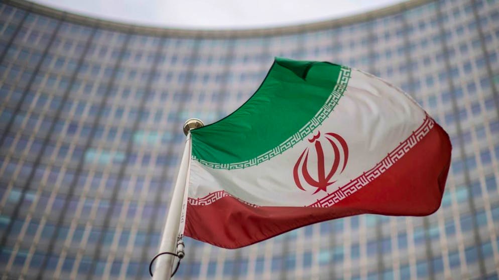 ARCHIV - Eine iranische Nationalflagge weht vor dem Gebäude der Internationalen Atomenergiebehörde (IAEA). Foto: Michael Gruber/AP/dpa