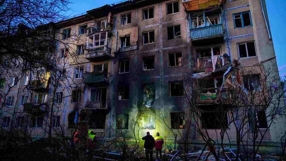 dpatopbilder - Local authority workers look at a residential building damaged after a Russian attack on Kiev. Photo: Evgeniy Maloletka/AP/dpa