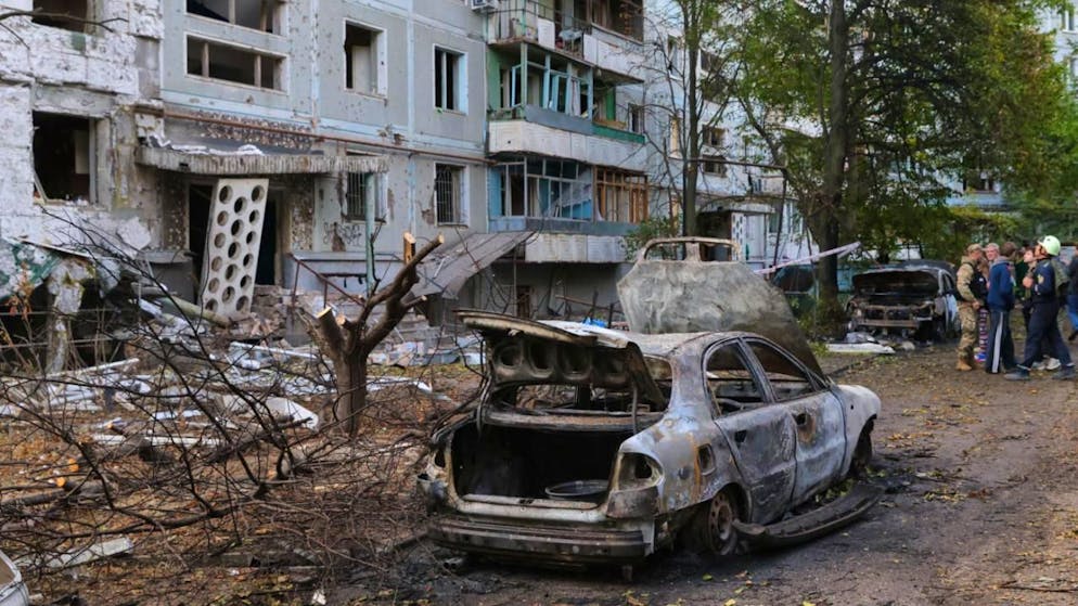 ARCHIV - Verbrannte Autos und beschädigte Wohngebäude sind nach einem russischen Angriff in Saporischschja zu sehen. Foto: Kateryna Klochko/AP/dpa