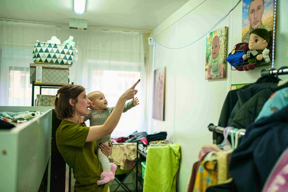 On November 23, 29-year-old Tetiana shows her ten-month-old daughter a picture of her father Denis, who died in the war. The two now live in Bucha in a shelter for refugees., 29, shows her 10-month-old daughter Sofia a photo of her father Denis, a Ukrainian serviceman who was killed at the frontline, at the hostel for internally displaced people in Bucha, Ukraine, on Sunday, Nov. 23, 2025. (AP Photo/Evgeniy Maloletka)