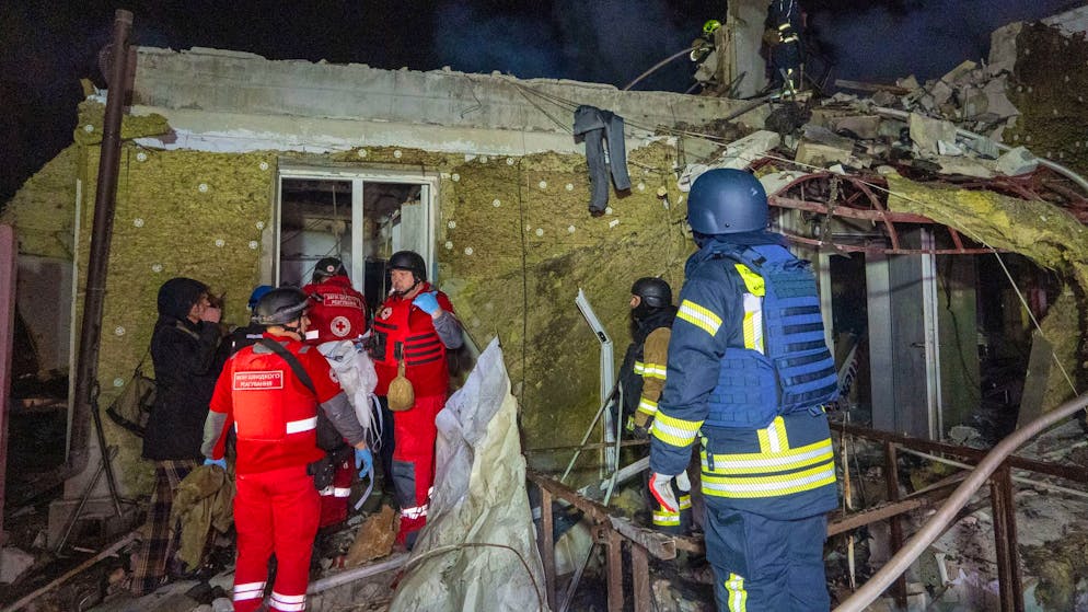 Während in Genf verhandelt wurde, griff Moskau weiter an: Rettungskräfte im Einsatz vor einem schwer beschädigten Wohngebäude in Charkiw Sonntagnacht. (23. November 2025).