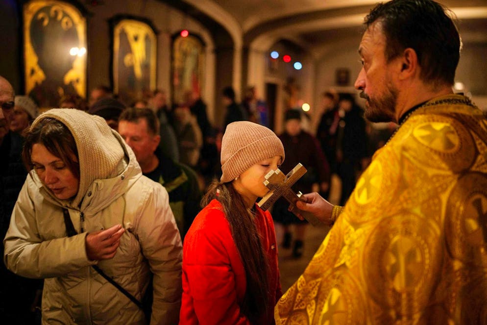 A girl kisses the cross at the Church of St. Andrew the Apostle in Butsha on November 23.