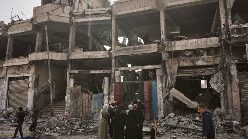 ARCHIV - Palästinenser inspizieren einen Tag nach einem israelischen Angriff auf ein Gebäude in Gaza die Ruinen. Foto: Jehad Alshrafi/AP/dpa/Archiv